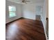 This bedroom has hardwood floors, a ceiling fan, and a window that provides natural light with nice views at 2511 Dalmahoy Ln, Fuquay Varina, NC 27526