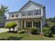 Charming two-story home featuring stone accents, a covered porch, and a well-manicured lawn at 2511 Dalmahoy Ln, Fuquay Varina, NC 27526