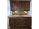Kitchen island with granite countertops, undermount lighting, and dark wood cabinets at 2511 Dalmahoy Ln, Fuquay Varina, NC 27526