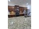 Bright kitchen with stainless appliances, granite counters, mosaic backsplash, and dark wood cabinets at 2511 Dalmahoy Ln, Fuquay Varina, NC 27526