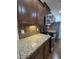 Modern kitchen featuring stainless steel appliances, granite countertops, and dark wood cabinetry at 2511 Dalmahoy Ln, Fuquay Varina, NC 27526