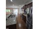 Open kitchen with stainless steel appliances and bar seating area, leads to dining and living spaces at 2511 Dalmahoy Ln, Fuquay Varina, NC 27526