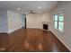 Cozy living room with hardwood floors, fireplace, and ample natural light from large windows at 2511 Dalmahoy Ln, Fuquay Varina, NC 27526