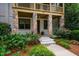 A front entrance is flanked by columns with stonework, lush foliage, and a small porch at 253 Tobacco Farm Way, Chapel Hill, NC 27516
