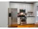 Modern kitchen with stainless steel appliances, white cabinetry, and hardwood floors at 253 Tobacco Farm Way, Chapel Hill, NC 27516