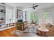 Bright living room with built-in bookshelves, fireplace, and large windows and hardwood floors at 253 Tobacco Farm Way, Chapel Hill, NC 27516