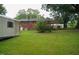 Backyard with a brick house, green grass and mature trees at 2626 Crestline Ave, Raleigh, NC 27603