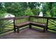 View of a wooden deck with a built-in bench surrounded by mature trees at 2626 Crestline Ave, Raleigh, NC 27603