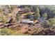 Aerial view of home site with private pond, home, and outbuildings amid lush trees and landscape at 2630 Ponderosa Rd, Cameron, NC 28326