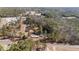 Aerial view showcases land with mature trees, a pond, and residential structures creating private country living at 2630 Ponderosa Rd, Cameron, NC 28326