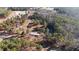 This aerial view captures a charming property with two houses, a pond, and a barn nestled among lush trees at 2630 Ponderosa Rd, Cameron, NC 28326