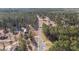 This aerial view features a property with a home, pond, and a barn, all surrounded by lush trees at 2630 Ponderosa Rd, Cameron, NC 28326