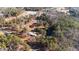 This aerial view shows a charming property with two houses, a pond, and a storage building nestled among lush trees at 2630 Ponderosa Rd, Cameron, NC 28326