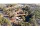 This aerial view showcases a charming property with two houses, a pond, and a storage building, surrounded by lush trees at 2630 Ponderosa Rd, Cameron, NC 28326