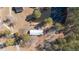 This aerial view shows a house with a metal roof and a pond surrounded by trees at 2630 Ponderosa Rd, Cameron, NC 28326