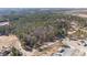 Expansive aerial view of wooded acreage showing a road and multiple structures on the property at 2630 Ponderosa Rd, Cameron, NC 28326