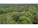 Expansive wooded acreage with mature trees and a winding road leading to the property in a scenic location at 2706 Montgomery St, Durham, NC 27705