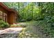 View of the home's brick patio with surrounding landscaping and wooded backyard area at 2706 Montgomery St, Durham, NC 27705