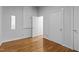 Bright bedroom featuring hardwood floors, a small window, and multiple doors to adjacent rooms at 2706 Montgomery St, Durham, NC 27705