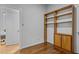 Bright bedroom showcasing hardwood floors, a built-in bookshelf, and a door to adjacent rooms at 2706 Montgomery St, Durham, NC 27705