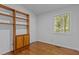 Bright bedroom showcasing hardwood floors, a built-in bookshelf, and a window offering natural light at 2706 Montgomery St, Durham, NC 27705