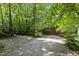 Long gravel driveway leading to a brown wooden house surrounded by lush greenery and mature trees at 2706 Montgomery St, Durham, NC 27705