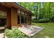 Wooden home with sliding glass doors that lead to a brick patio and green, lush backyard at 2706 Montgomery St, Durham, NC 27705