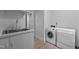 Well lit laundry area featuring Miele washer and dryer and sink with bright cabinets at 2706 Montgomery St, Durham, NC 27705