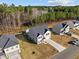 Aerial view of houses with lush greenery and forestry behind the homes on a sunny day with scattered clouds at 274 E Boulder Road Rd, Henderson, NC 27537