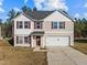 Charming two-story home with red shutters, a two-car garage, and a welcoming front entrance at 274 E Boulder Road Rd, Henderson, NC 27537