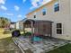 Cozy backyard patio with a covered pergola, stone pavers, outdoor furniture, and partial view of the house at 274 E Boulder Road Rd, Henderson, NC 27537