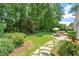 Lush backyard oasis featuring a stone patio, dining area, and mature trees for privacy at 300 Bordeaux Ln, Cary, NC 27511
