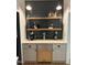 Charming bar area features sleek subway tiles, wooden shelves, and a beverage refrigerator for entertaining at 300 Bordeaux Ln, Cary, NC 27511