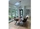 Dining room with large windows overlooking a garden, hardwood floors, and modern decor at 300 Bordeaux Ln, Cary, NC 27511