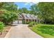 Brick home boasts a long driveway, 3-car garage, manicured lawn, and beautiful landscaping at 300 Bordeaux Ln, Cary, NC 27511