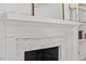Close up of an all-white fireplace and mantle with white brick and black firebox at 300 Bordeaux Ln, Cary, NC 27511