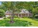 Charming brick home featuring a manicured lawn, lush landscaping, and a welcoming front porch at 300 Bordeaux Ln, Cary, NC 27511