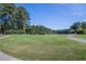 Beautiful green fairway on the golf course, framed by trees and a blue sky at 300 Bordeaux Ln, Cary, NC 27511