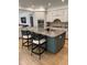 Kitchen island with a stone countertop, seating, and modern appliances in an open layout at 300 Bordeaux Ln, Cary, NC 27511