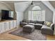 Comfortable living room with an attic window providing natural light, built-in storage, and a large sectional sofa at 300 Bordeaux Ln, Cary, NC 27511