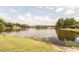 Calm lake view with verdant grass and trees; a peaceful natural landscape at 300 Bordeaux Ln, Cary, NC 27511