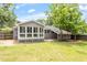 Home's backyard featuring a spacious yard, patio, sunroom, and mature trees for shade at 3325 Old Buffaloe Rd, Raleigh, NC 27604