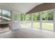 Bright sunroom with many windows, light grey flooring, white vaulted ceilings, and a door to the outside at 3325 Old Buffaloe Rd, Raleigh, NC 27604