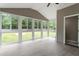 This sunroom features vaulted ceilings, light grey flooring, and neutral wall colors with a view of the yard at 3325 Old Buffaloe Rd, Raleigh, NC 27604