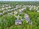 A lovely home sits among well-maintained lawns and mature trees in this aerial community view at 4 Pickard Pl, Durham, NC 27703