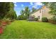 Expansive backyard featuring lush green lawn, mature trees, a trampoline and manicured landscaping at 4 Pickard Pl, Durham, NC 27703