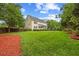 Expansive backyard featuring lush green lawn, mature trees, and manicured landscaping at 4 Pickard Pl, Durham, NC 27703