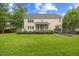 Expansive backyard featuring lush green lawn, mature trees, a trampoline and manicured landscaping at 4 Pickard Pl, Durham, NC 27703