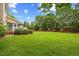 Large backyard featuring lush green lawn, mature trees, and manicured landscaping at 4 Pickard Pl, Durham, NC 27703