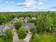 Aerial view of a two-story home with a long driveway, lush lawn, and mature trees at 4 Pickard Pl, Durham, NC 27703